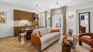 A modern living room with a sofa, coffee table, and dining area. - Lavie Maison - Spa Bath & AC, Heart of Saint-Merri (Paris)