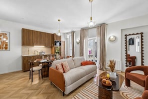 A modern living room with a sofa, coffee table, and dining area. - Lavie Maison - Spa Bath & AC, Heart of Saint-Merri (Paris)