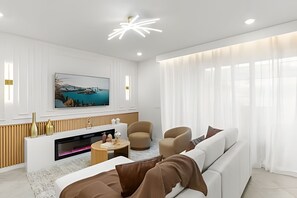 A modern living room with a fireplace, a sofa, a coffee table, and a television mounted on the wall. - 5 Bd / 4.5 Ba / Sleeps 14 / Windsor Cay Resort (Clermont)