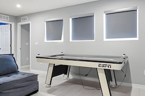 A room with a pool table, a couch, and three windows. - 7 Bd / 6,5 Ba / Sleeps 18 / Solara Resort (Kissimmee)