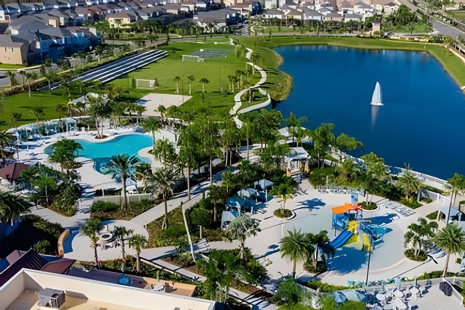 A resort with a large pool, a water slide, and a fountain.