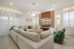A modern living room with a sectional sofa, a flat-screen TV, and a fireplace. - 8 Bd / 6 Ba / Sleeps 23 / Windsor Cay Resort (Clermont)