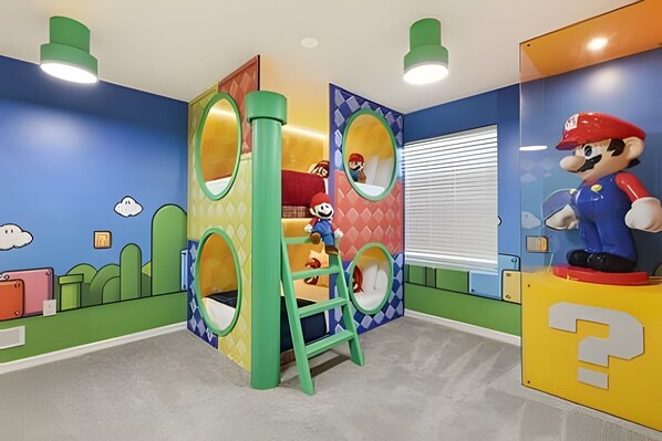 A children's play area with colorful walls, a Mario statue, and a ladder.