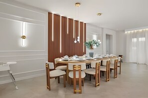Een eetruimte met een ronde tafel, stoelen en een decoratieve scheiding.