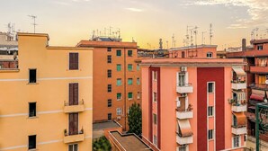 A row of multi-story residential buildings with balconies and satellite dishes. - Terrazza di Jo (Roma)