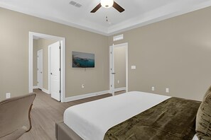 A bedroom with a bed, a chair, a ceiling fan, and a painting on the wall. - 6 Bd / 3,5 Ba / Sleeps 22 / Reunion Village (Kissimmee)