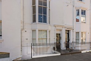A white building with multiple windows and a black metal fence in front. - Host & Stay | Clarendon Violet (Brighton and Hove)