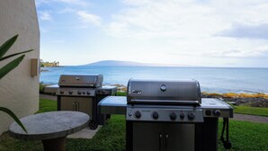 Twee barbecues, een klein rond tafeltje en uitzicht op de oceaan.