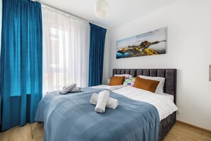 Ein Hotelzimmer mit Bett, einem Gemälde und einem Fenster mit Vorhängen.