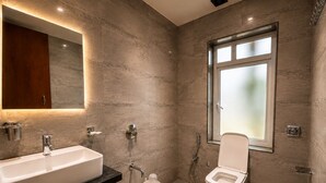Un bany modern amb un lavabo ampli, vàter i dutxa.