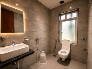 Een moderne badkamer met een groot wastafel, toilet en douche.