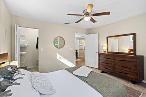 A bedroom with a bed, a dresser, a mirror, and a ceiling fan. - Private1-bedroom cottage on “Swamp Magic Farm” close to Gainesville (Micanopy)