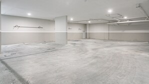 Un'ampia stanza vuota con soffitto alto, condotti a vista e pavimento pulito e grezzo.