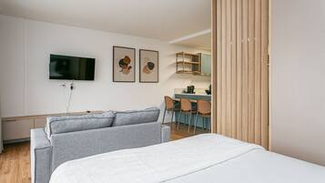 Una habitación de hotel moderna con cama, televisor y obras de arte en la pared.