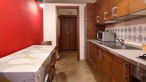 A kitchen with wooden cabinets, a microwave, and a sink. - Hostmate - Bari - Trento (Bari)