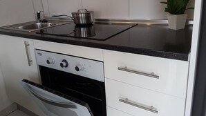 A modern kitchen with a stove, oven, and a sink. - Vacation Apartment 'En Mareverde Resort' with Sea View, Wi-Fi and Air Conditioning (Costa Adeje)
