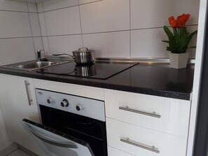 A modern kitchen with a stove, oven, and a sink. - Vacation Apartment 'En Mareverde Resort' with Sea View, Wi-Fi and Air Conditioning (Costa Adeje)