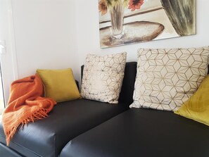 A black sofa with patterned cushions and a blanket. - Vacation Apartment 'En Mareverde Resort' with Sea View, Wi-Fi and Air Conditioning (Costa Adeje)