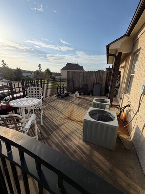 Terraza en la azotea con mobiliario exterior, cerca de madera y unidades de aire acondicionado.
