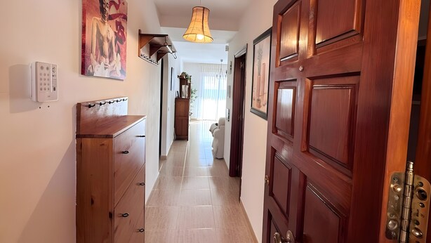 A hallway with wooden doors, a ceiling light, and a wall-mounted thermostat. - 'El Galeón' Bright Apartment with Partial Sea View, Pool, and Wi-Fi (Adeje)