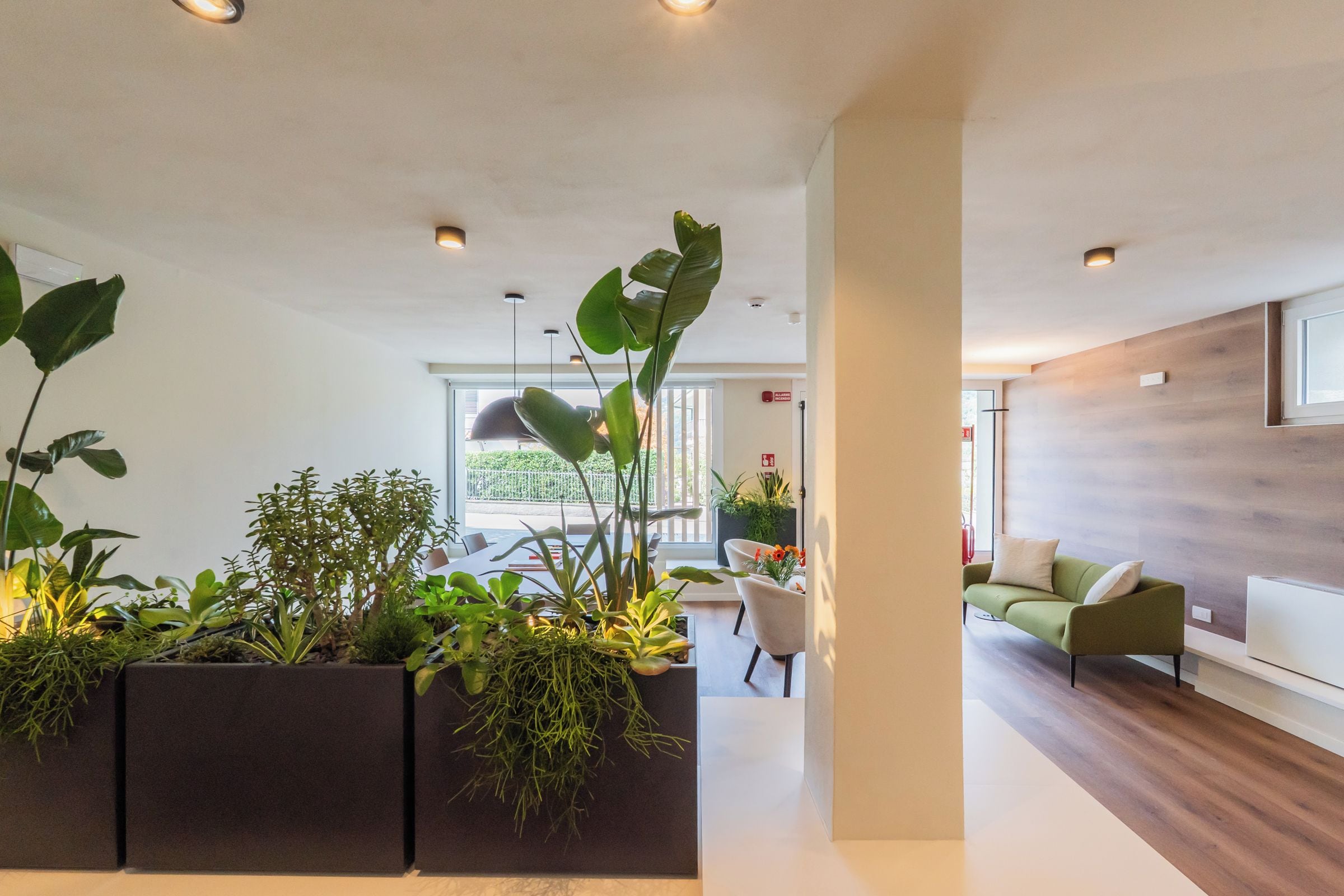 Ein modernes Interieur mit einer Rezeption, einer Sitzecke und Blick ins Freie.
