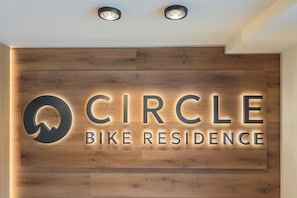 Un mur en bois avec une enseigne lumineuse indiquant « Circle Bike Residence ».