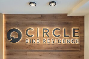Un mur en bois avec une enseigne lumineuse indiquant « Circle Bike Residence ».