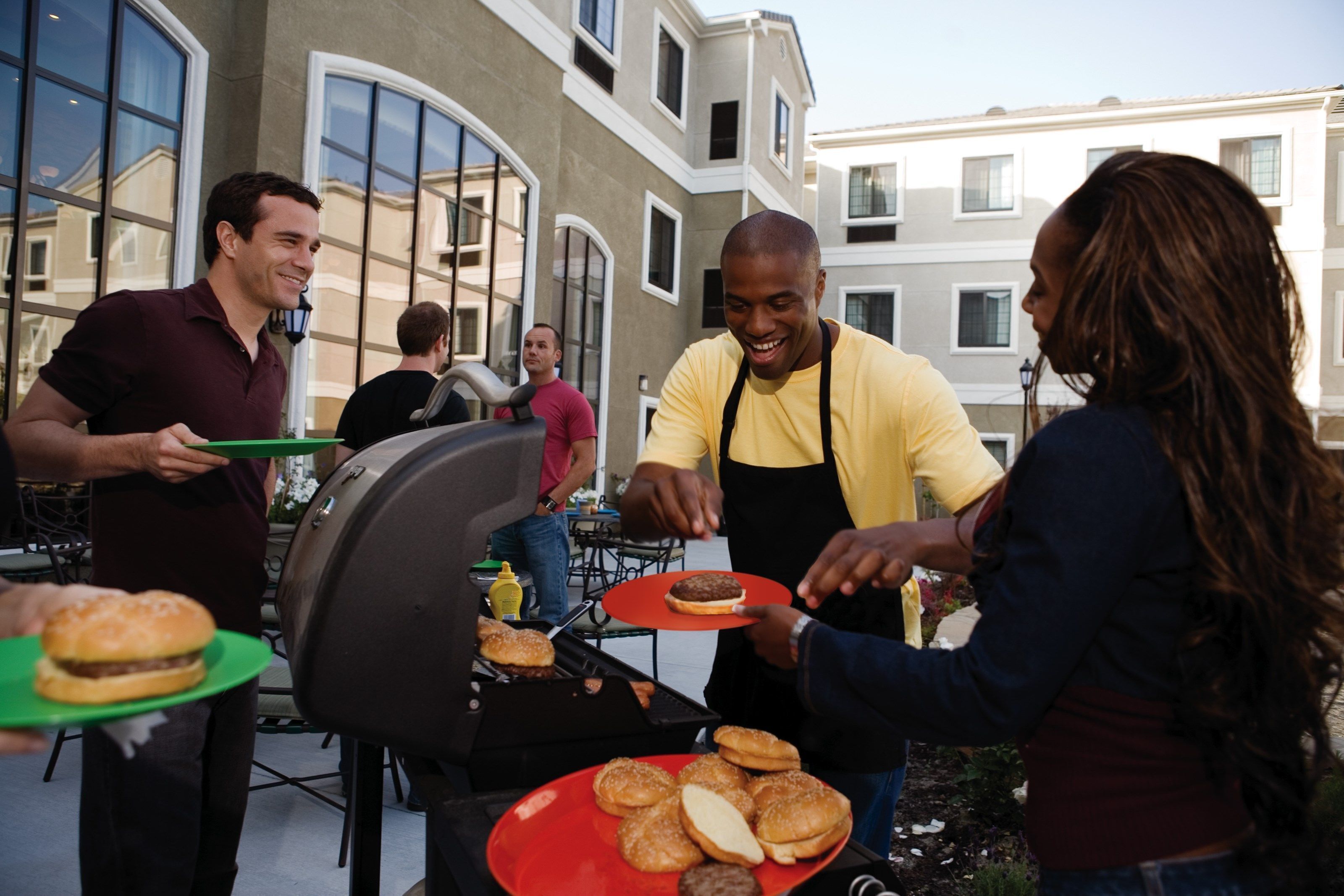 Ein Grillplatz mit Personen, die kochen und Essen servieren.
