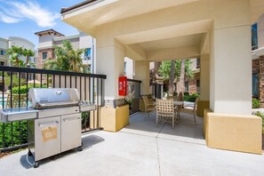 A covered outdoor patio with a barbecue grill, seating area, and poolside view. - Accessible 1BR Suite w/ Roll-In Shower + Breakfast (Glendale)