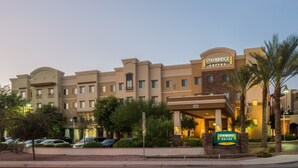 A Staybridge Suites hotel with a modern architectural design, featuring multiple balconies and a well-lit entrance.