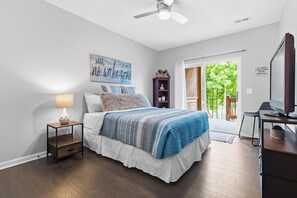 A bedroom with a bed, a desk, a chair, a lamp, and a ceiling fan. - Lake It Easy on the Cumberland 3VB- Lake Views, Hot Tub & Near Boat Ramp (Burnside)