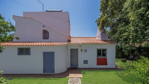Ein zweistöckiges Haus mit rotem Ziegeldach, einem kleinen Vorgarten und einem steinernen Weg zum Eingang.
