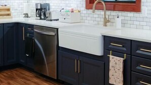 A kitchen with dark cabinets, a white countertop, and a window with a red frame. - At the Mountain Mist Retreat, we believe that a true getaway starts with a restful night and a seamless morning. Our 5-bedroom, 4-bathroom layout is thoughtfully designed to provide the perfect gathering. (Wintergreen)
