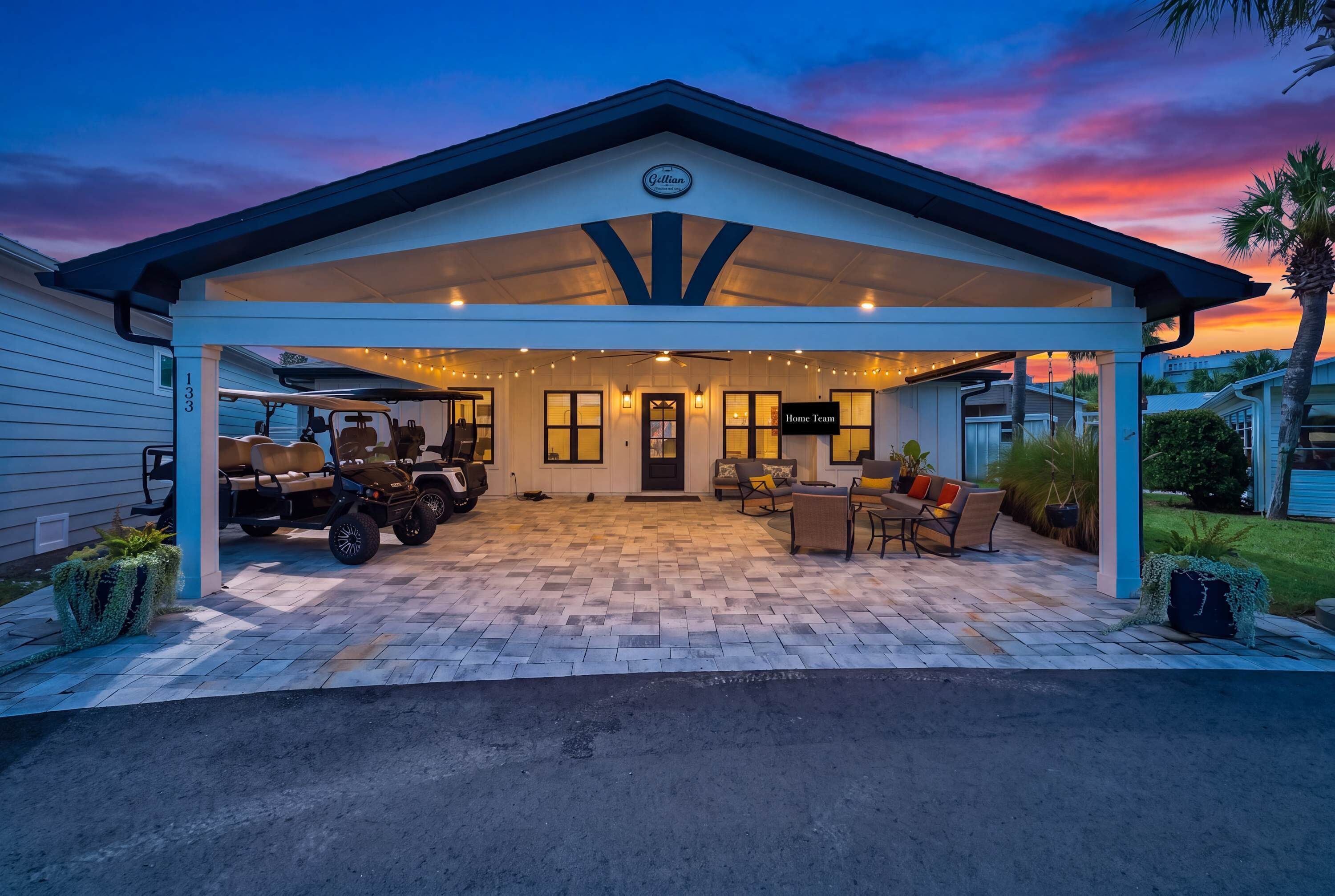 A covered outdoor area with a patio, seating, and golf carts.
