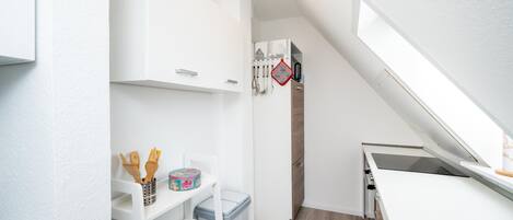 A compact kitchen with white cabinetry, a built-in oven, and a small countertop.