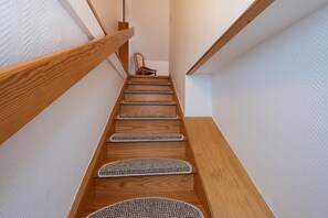 Eine Holztreppe mit Teppichstufen, die nach oben führt.