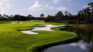 A golf course with sand bunkers, water hazards, and a pond. - Port St. Lucie | Golf Retreat | Pool + Spa | 2BR (Port St. Lucie)