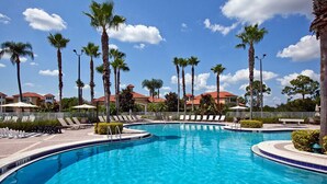 A swimming pool with lounge chairs and palm trees. - Port St. Lucie | Golf Retreat | Pool + Spa | 2BR (Port St. Lucie)