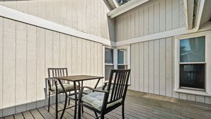 Une terrasse couverte avec une table et deux chaises.
