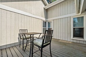 A covered patio with a table and two chairs. - Amazing Wildlife, Golf Cart Included - 15 Fairway Club (Fripp Island)