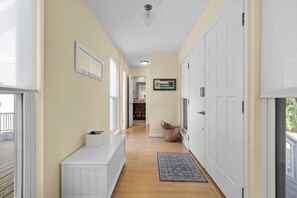A hallway with a white bench, a rug, and a basket. - Amazing Wildlife, Golf Cart Included - 15 Fairway Club (Fripp Island)