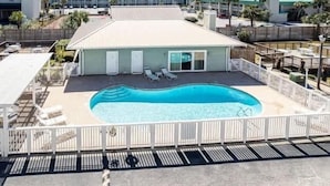 Et hotel med swimmingpool, liggestole og et afspærret område.