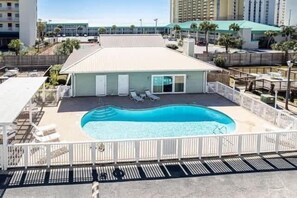 A hotel with a swimming pool, lounge chairs, and a fenced area. - Beachside Condo in Miramar Beach (Destin)