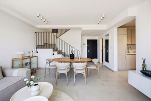 A modern interior with a dining area, staircase, and kitchen. - 3-bedroom duplex apartment in gorgeous Jerusalem with mamad (Jerusalem)