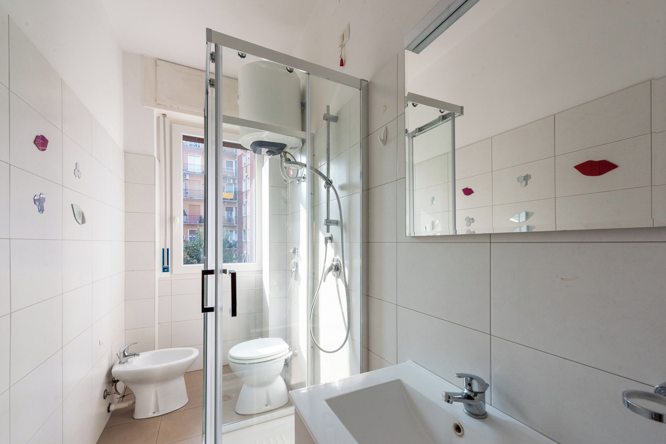 A modern bathroom with a glass-enclosed shower, a white toilet, and a sink.