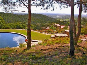 A pool surrounded by a landscaped garden with trees and a view of a distant landscape. - Quinta Sonhos, for romantic nature lovers, Lagos (Lagos)