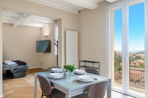 A dining area with a table set for four, a radiator, and a view of the countryside through a large window. - [Residenza la Guercia]Seaview-5 terre-A/C (La Spezia)