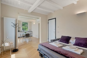 A modern bedroom with a bed, bedside tables, and a view of a dining area. - [Residenza la Guercia]Seaview-5 terre-A/C (La Spezia)