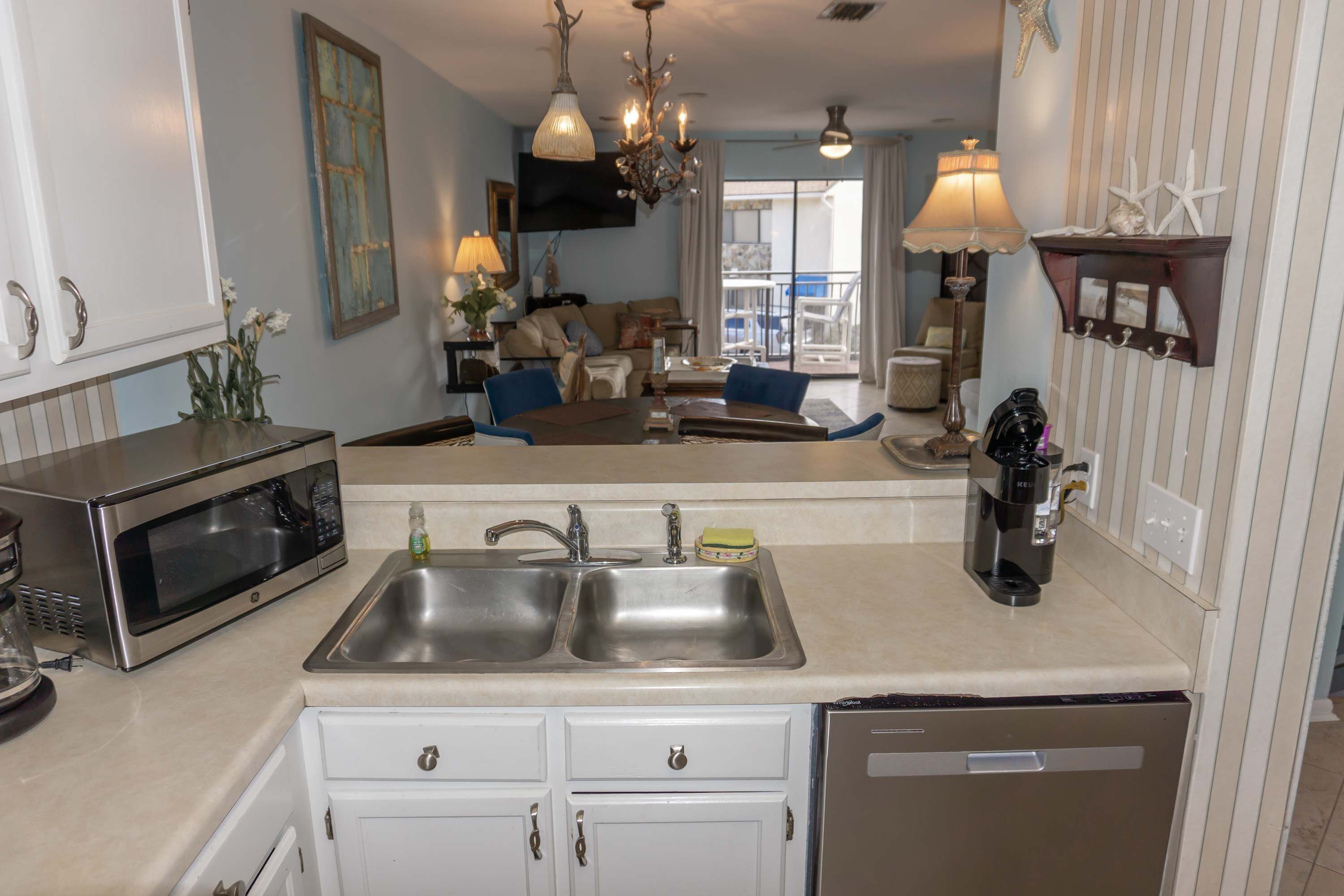 A kitchen with a double sink, a microwave, and a coffee maker.
