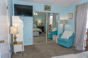 A room with a bed, a chair, a television, and a mirror. - Beachfront Villa with Sea Views  Bikes Included  Gulf Across St   Kayak Access (Miramar Beach)